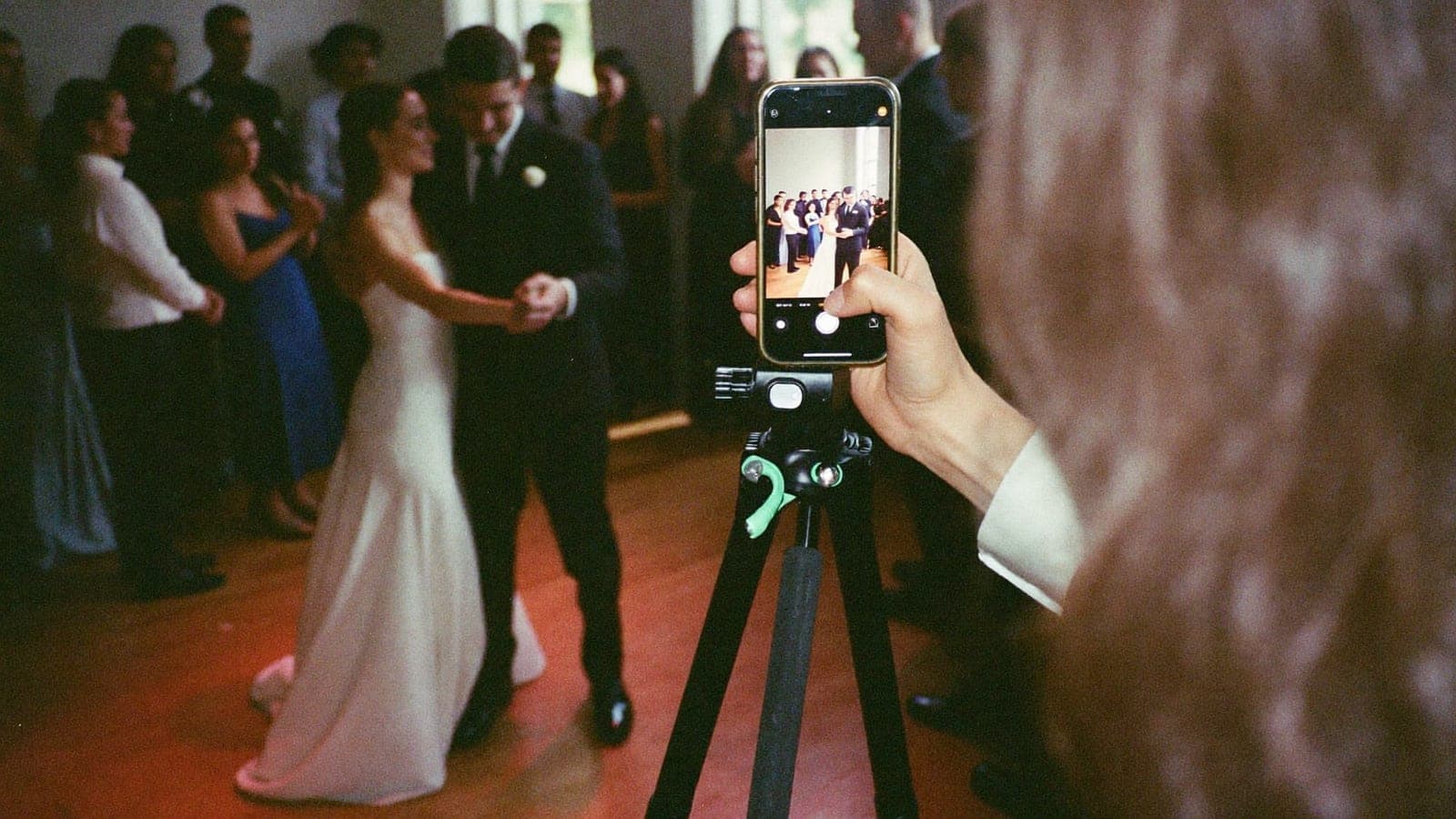 A phone on a tripod filming the couple's first dance