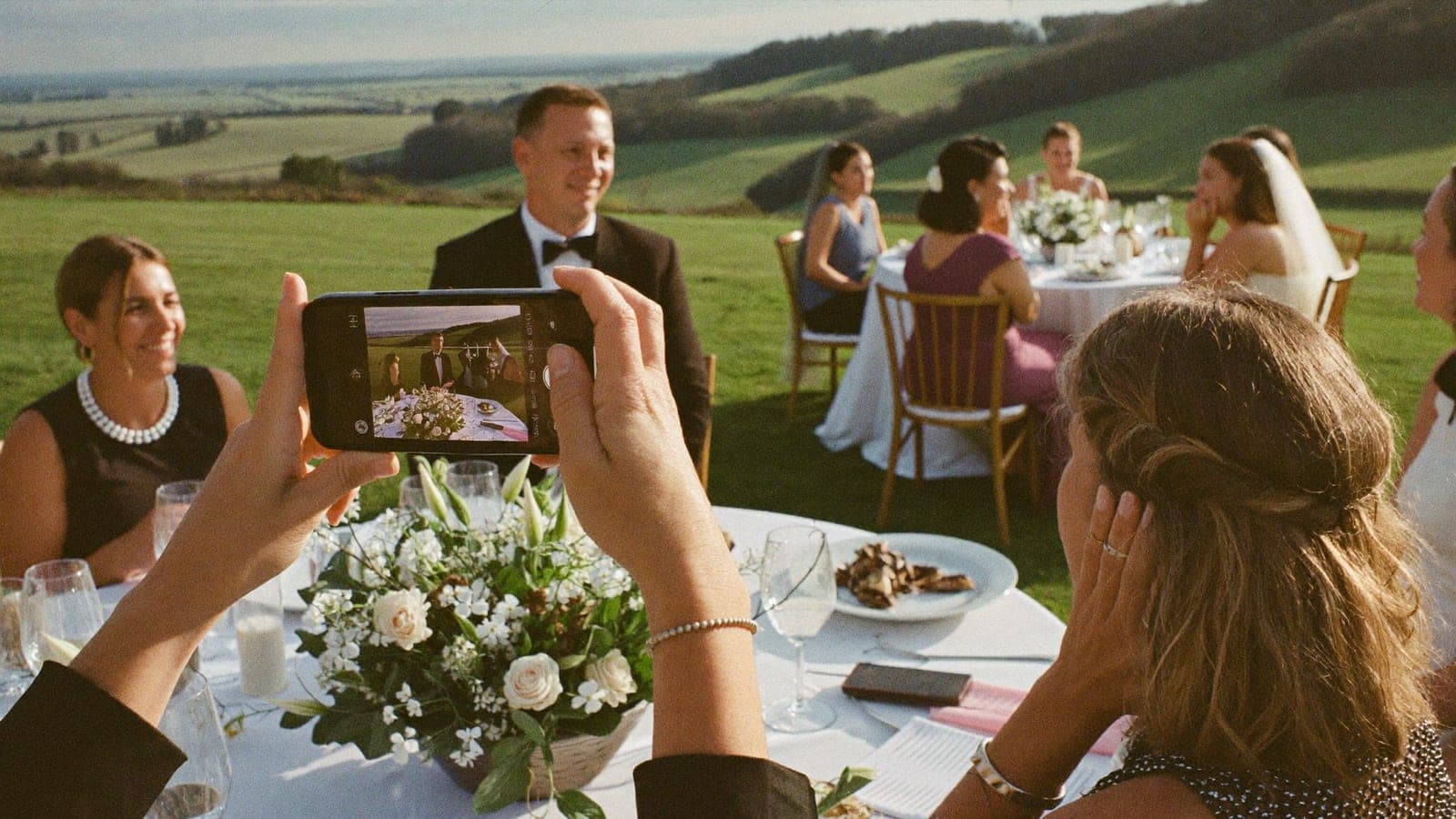 Ein Gast filmt die Rede des Trauzeugen beim Abendessen mit dem Handy