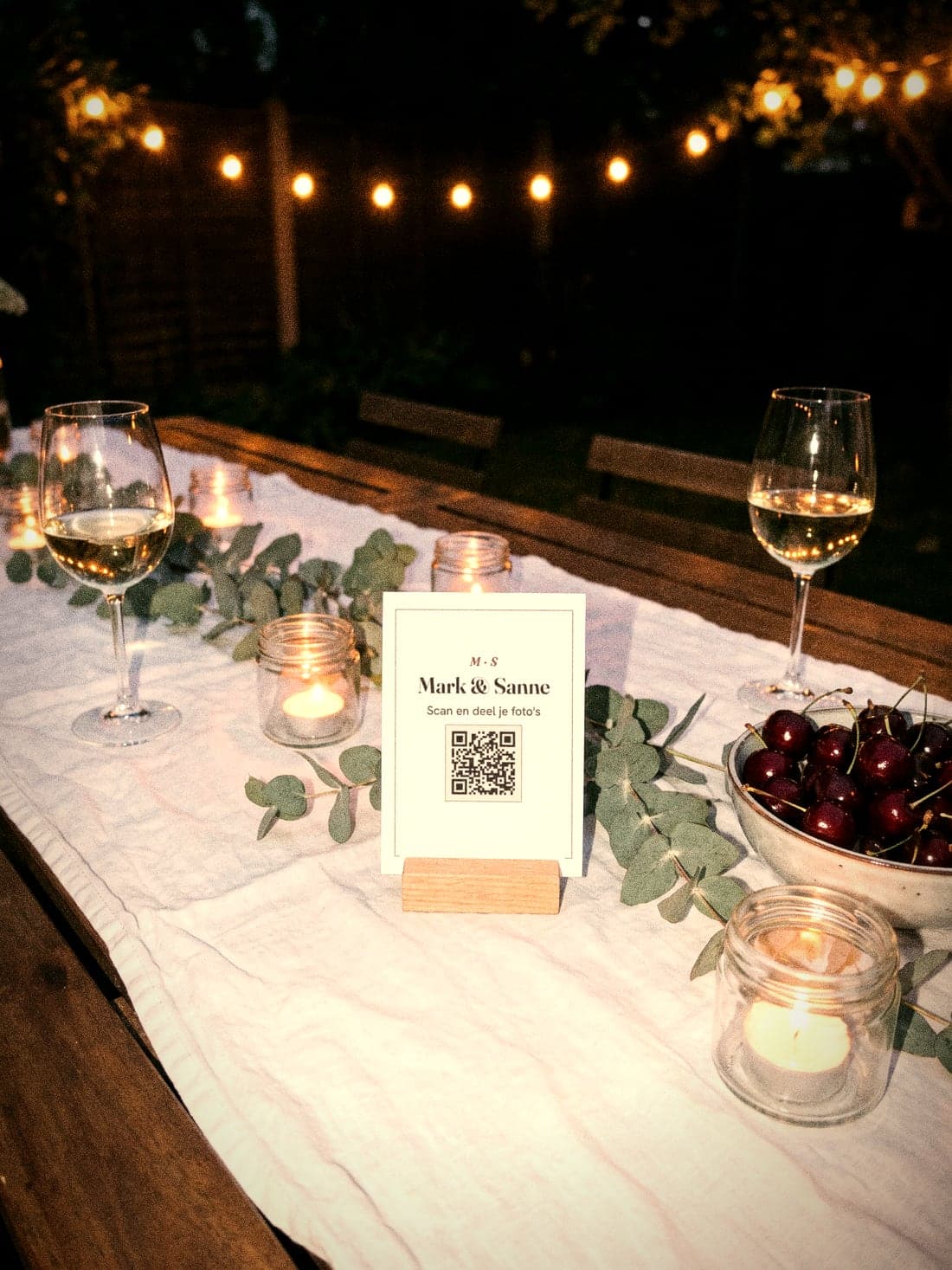 Mark & Sanne's QR table card between the candles and the cherries