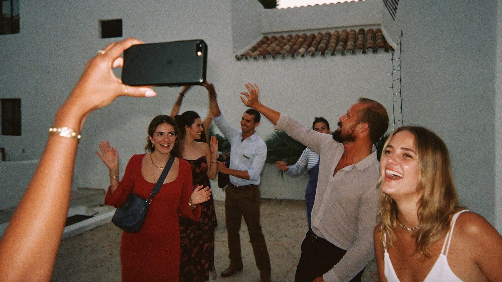 Una invitada hace con el móvil una foto con flash de amigos que bailan