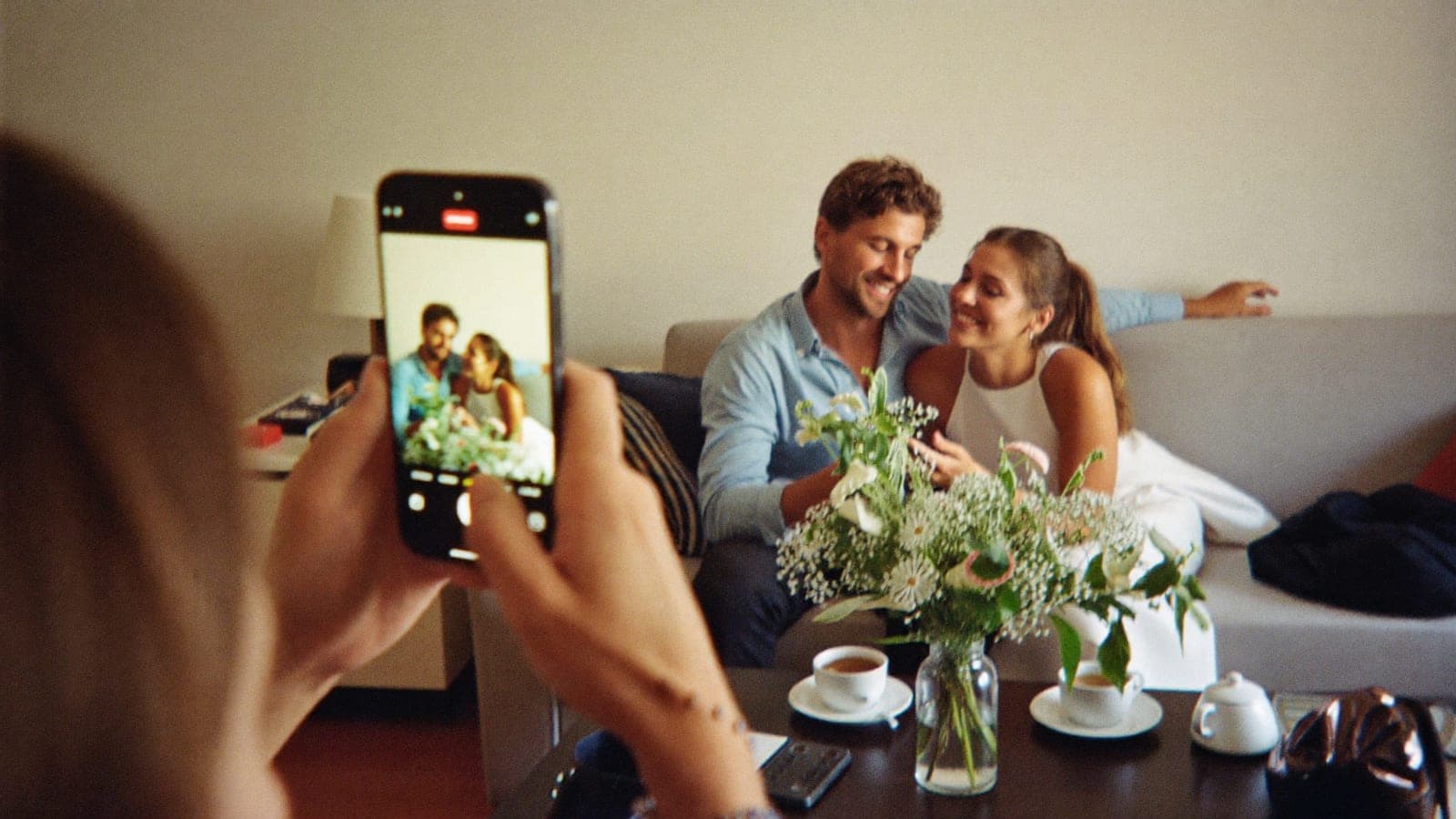 Los recién casados miran fotos juntos en el móvil la mañana después de la boda
