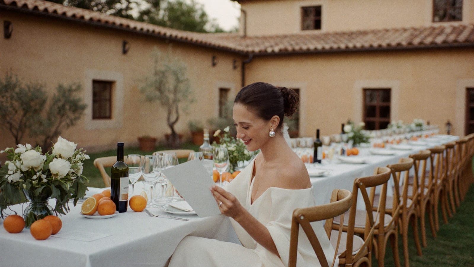 La novia lee una pequeña tarjeta junto a su plato