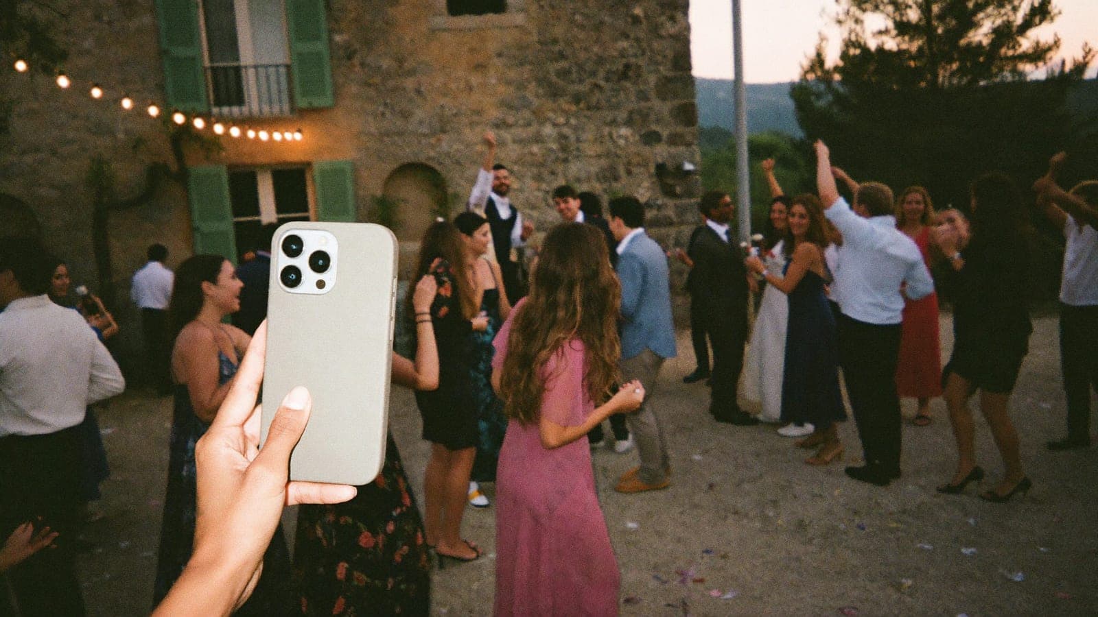 Un invité prend au téléphone une photo au flash d'amis qui dansent