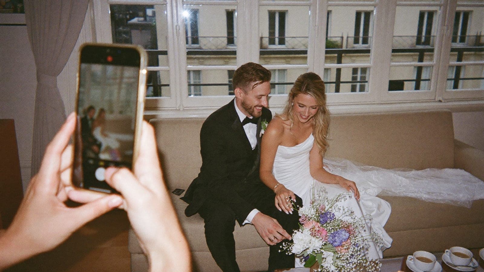Les jeunes mariés regardent ensemble des photos sur un téléphone le lendemain du mariage