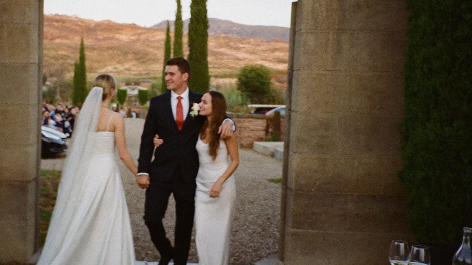 La mariée accueille une invitée venue avec son compagnon à l'entrée du domaine