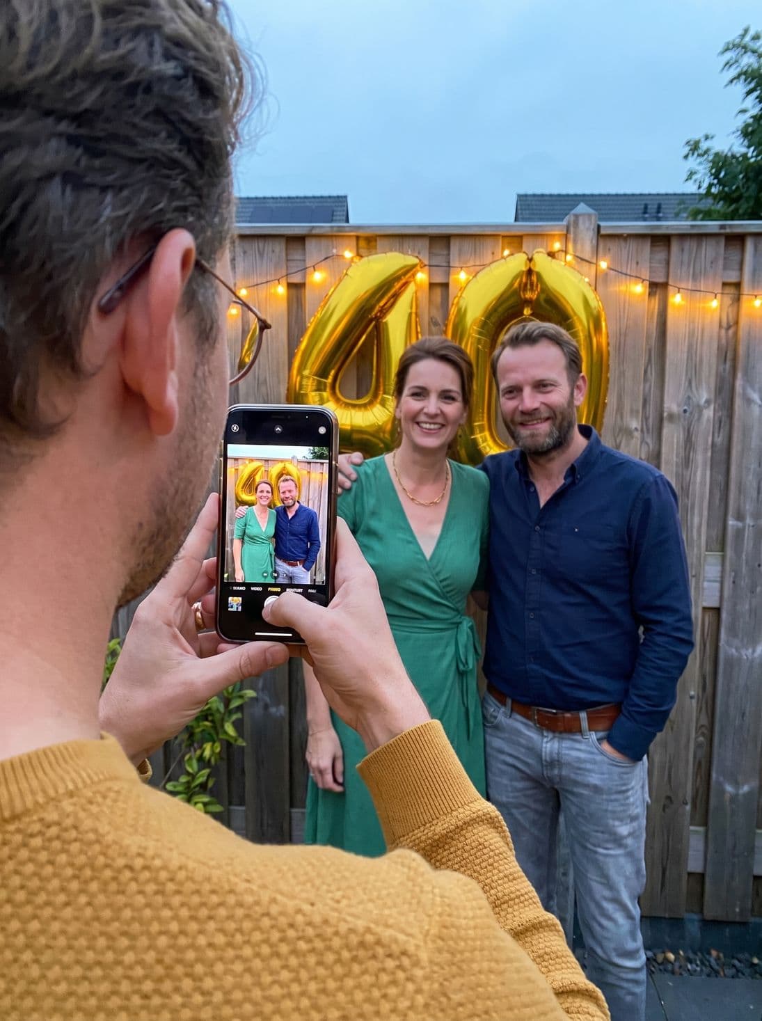 A guest photographs the birthday girl in front of the 40 balloons