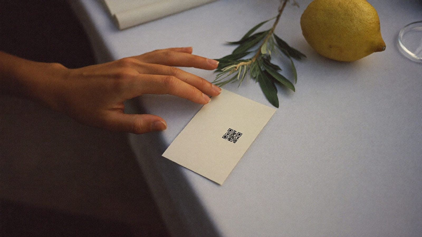 Un cartoncino con solo il codice QR sul tavolo del ricevimento, accanto a un limone