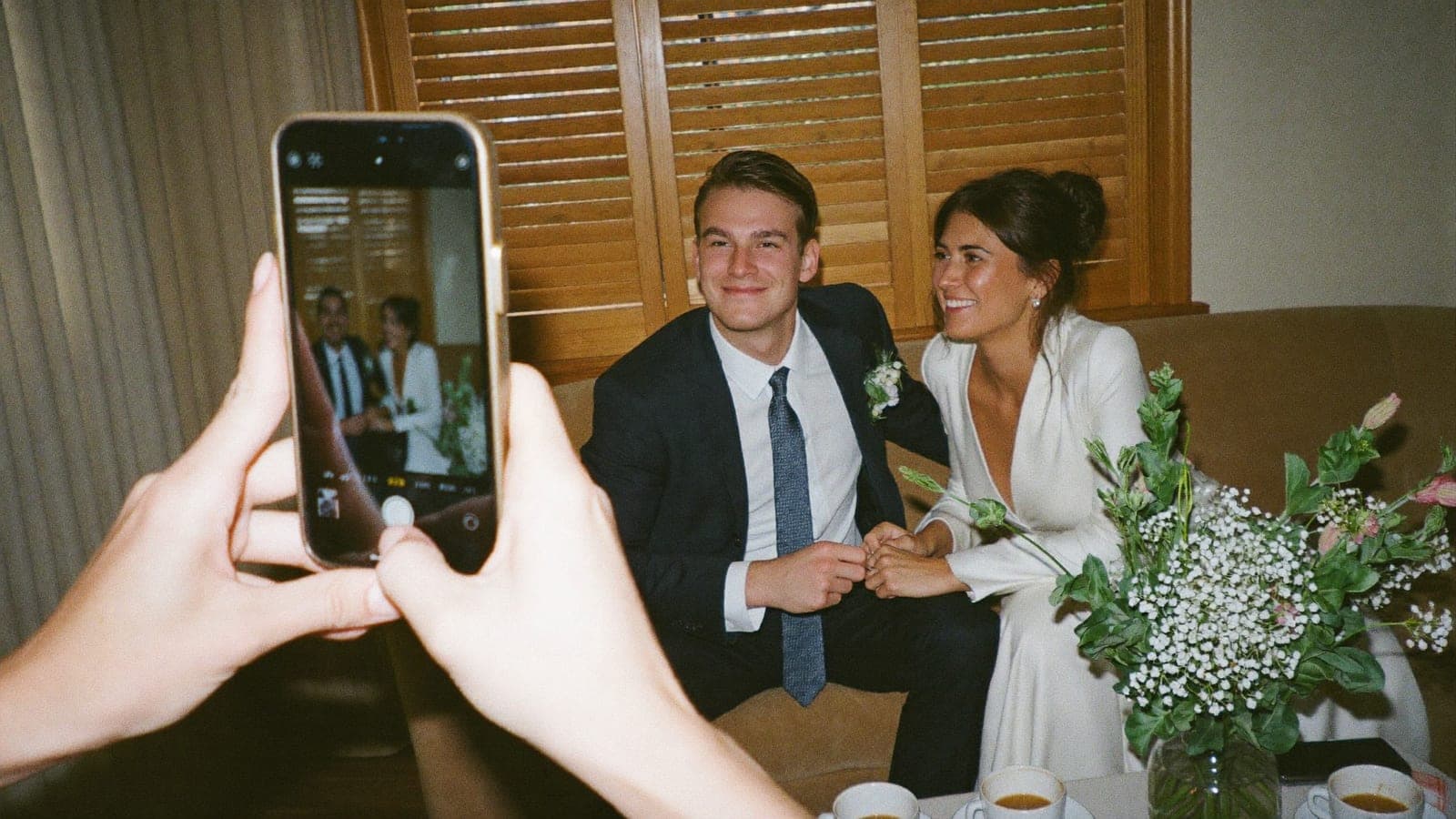 Gli sposi guardano insieme le foto sul telefono la mattina dopo il matrimonio