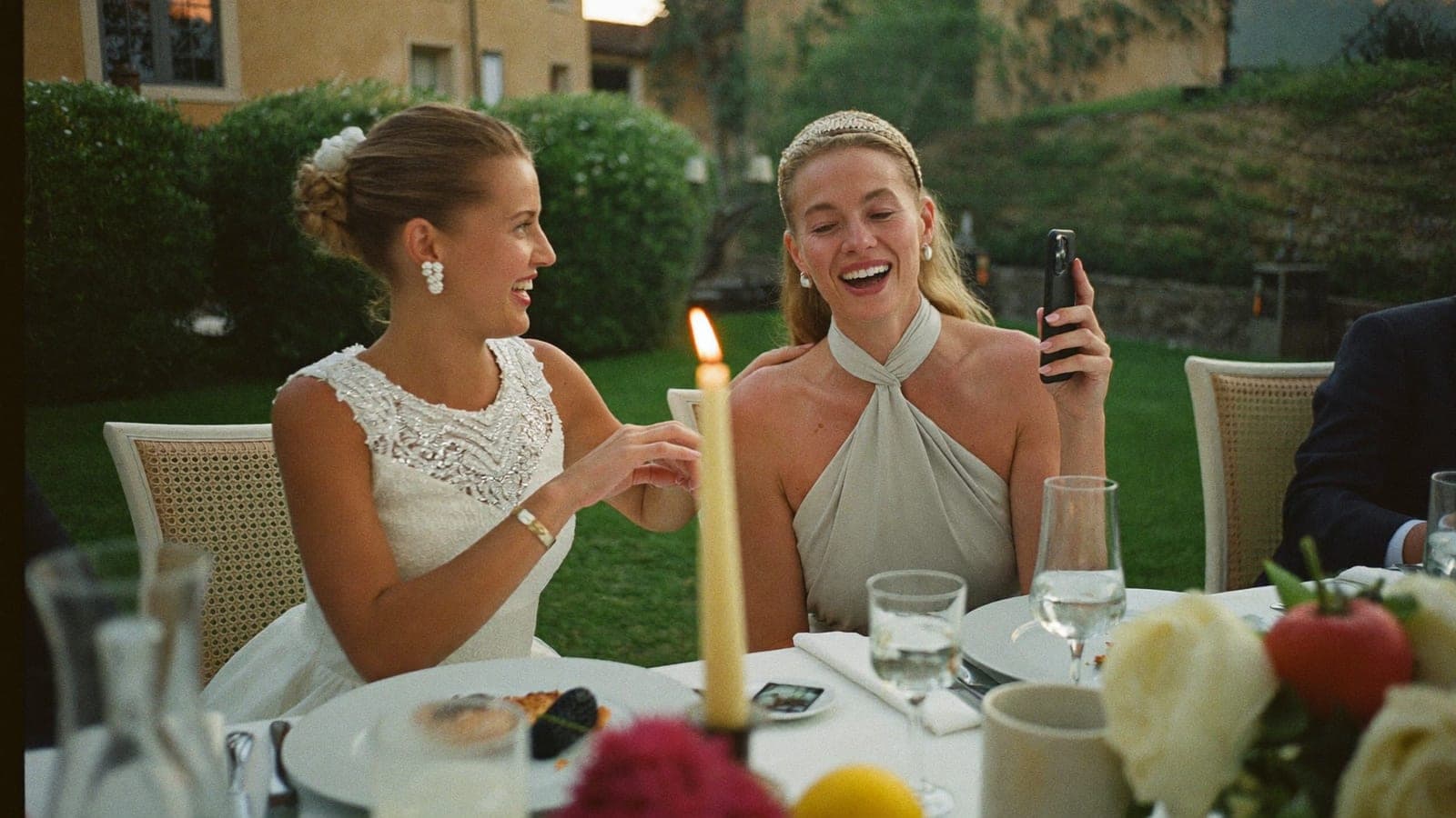 Due invitati ridono mentre registrano un videomessaggio con il telefono al ricevimento