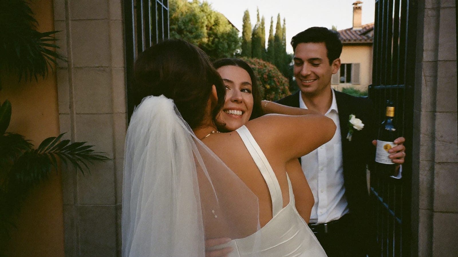 La sposa accoglie un'invitata arrivata con il partner all'ingresso della sala