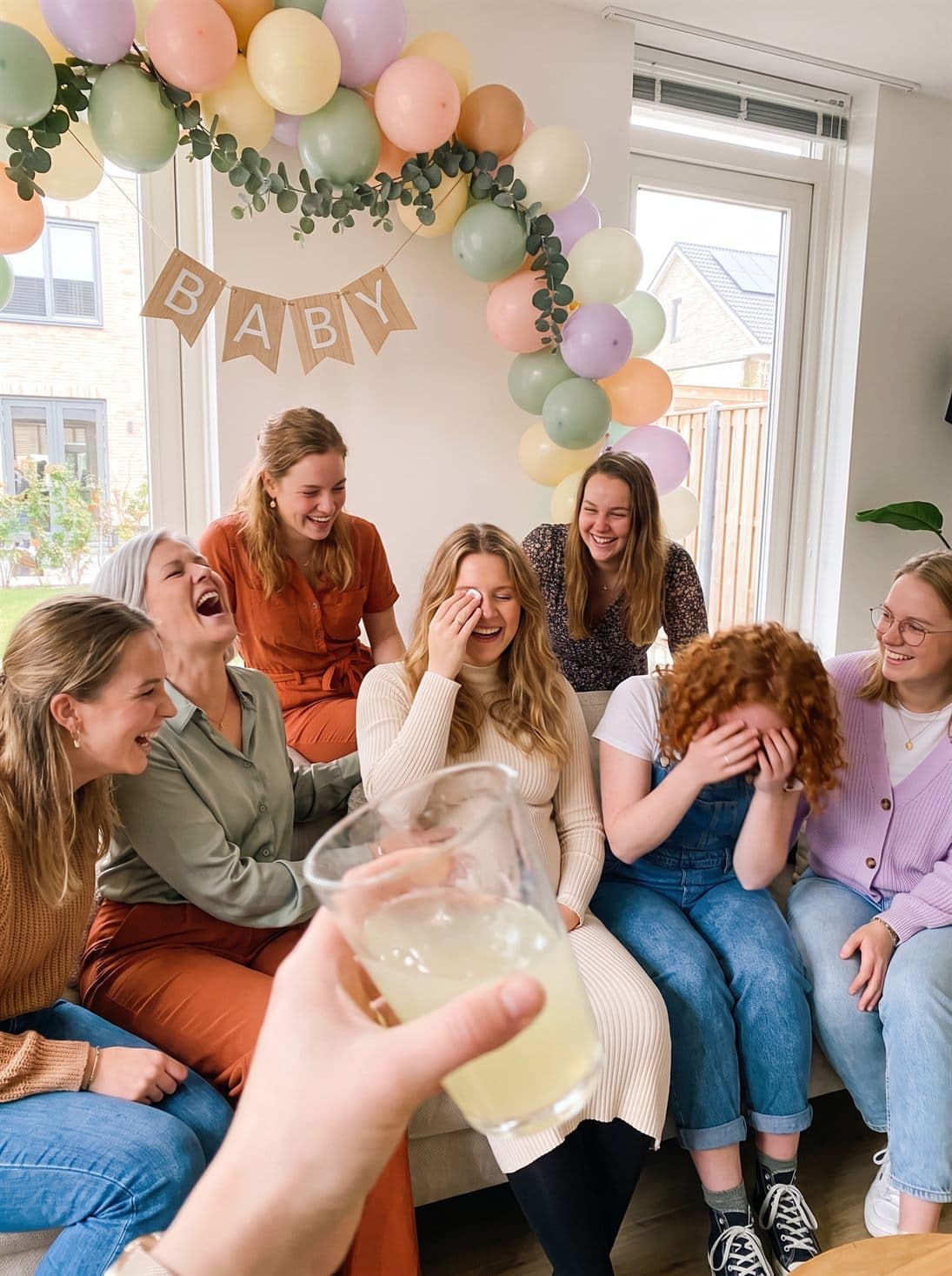The whole baby shower laughing on the couch