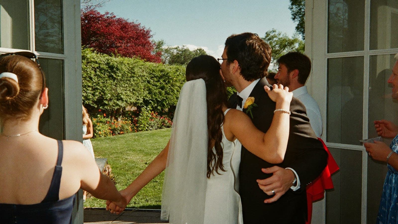 The bride hugging a guest who arrives with her partner