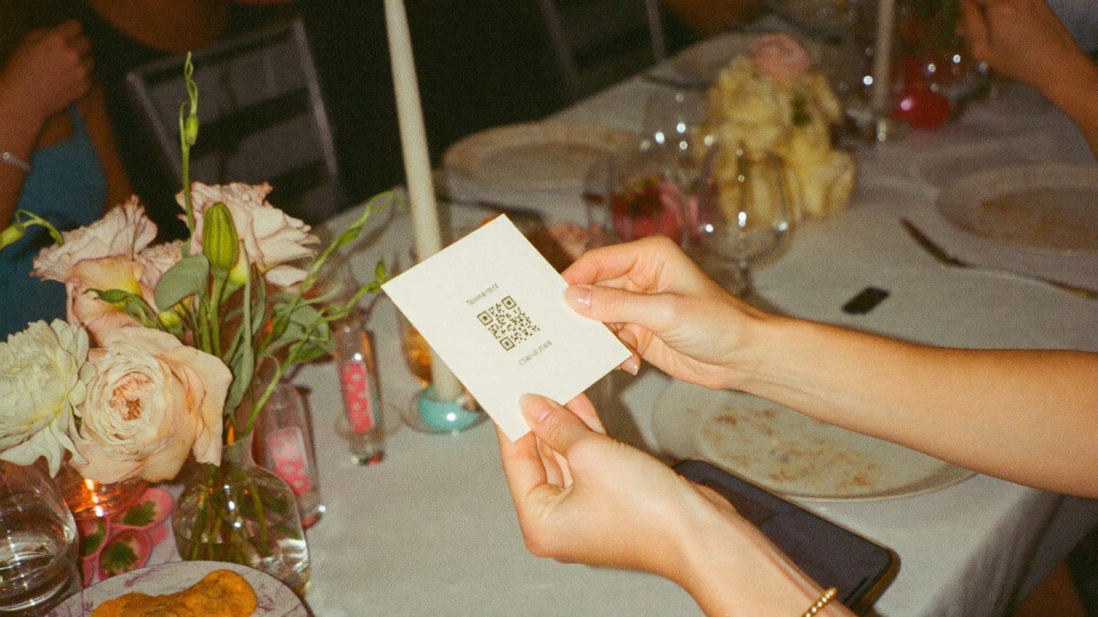 Ein Gast hält die QR-Tischkarte und scannt sie mit dem Handy