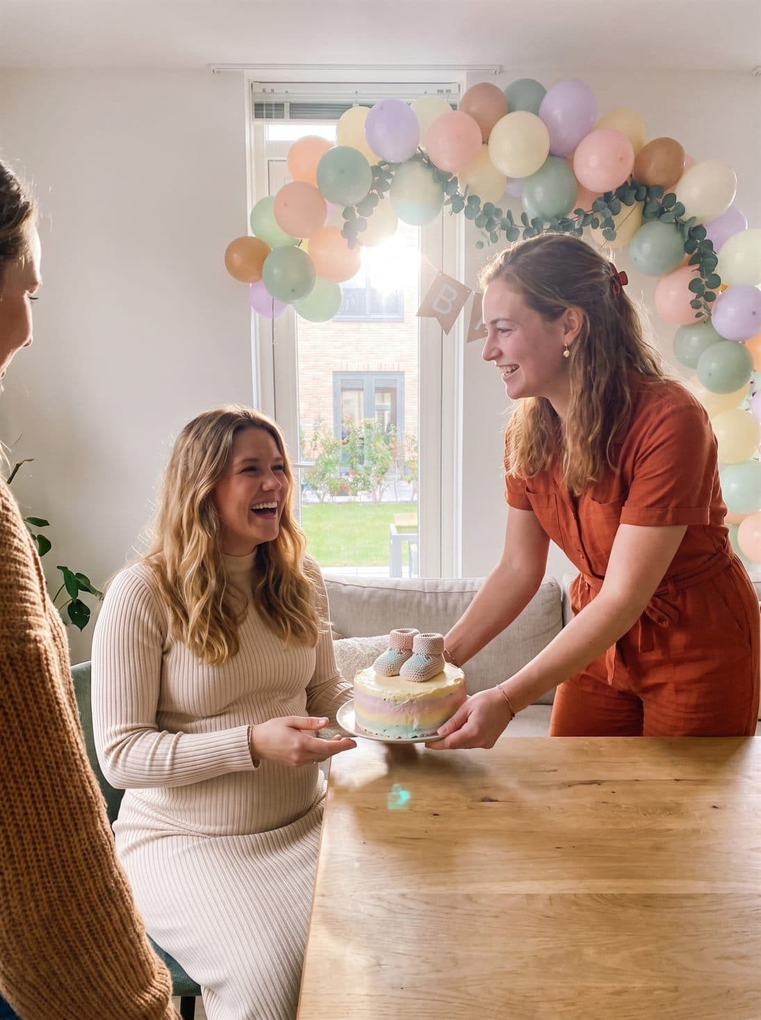 The baby shower cake with little booties is set on the table