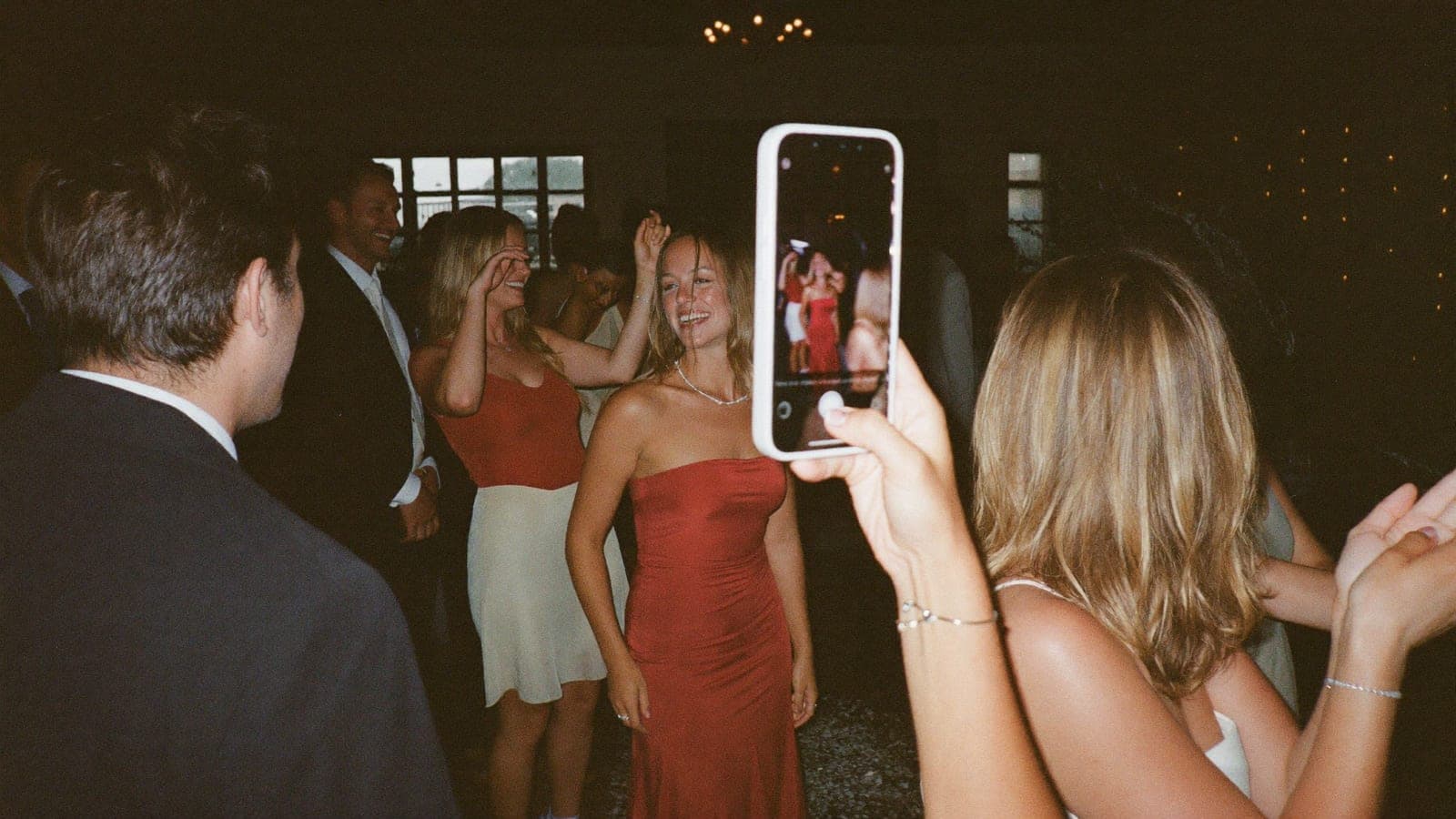 Bir davetli, dans eden arkadaşlarının telefonla flaşlı fotoğrafını çekiyor